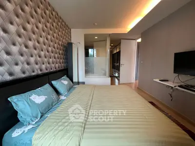 Modern bedroom with stylish decor and wall-mounted TV in a cozy apartment.