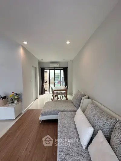 Modern living room with stylish furniture and natural light, featuring a cozy dining area and elegant decor.