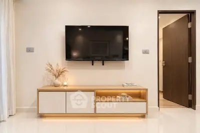 Modern living room with wall-mounted TV and stylish wooden cabinet