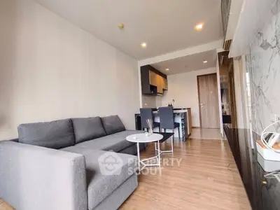 Modern living room with sleek gray sofa and open kitchen layout