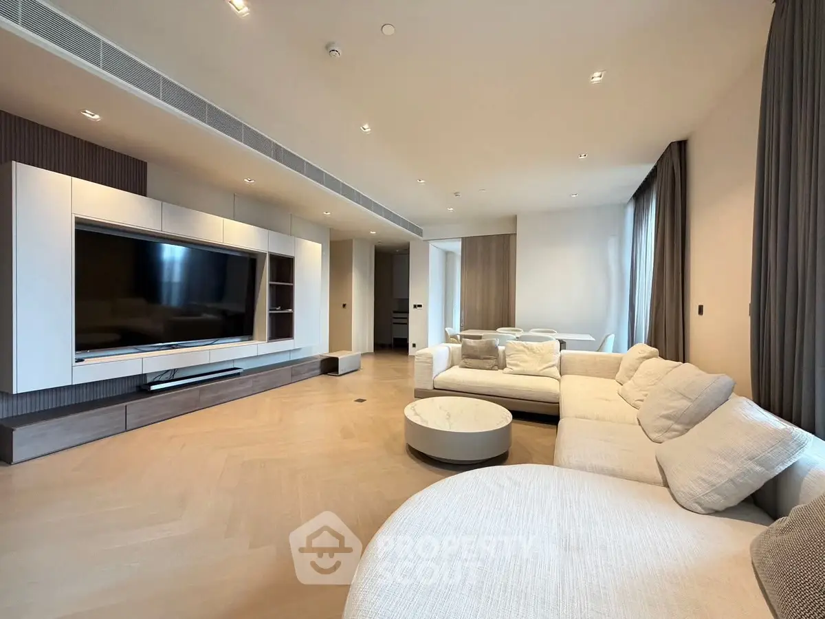 Luxurious modern living room with large TV and elegant furniture, perfect for relaxation and entertainment.