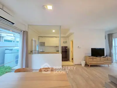 Spacious open-plan living room with modern kitchen and natural light.