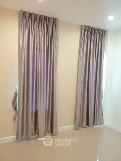 Elegant room with floor-to-ceiling curtains and glossy tiled flooring
