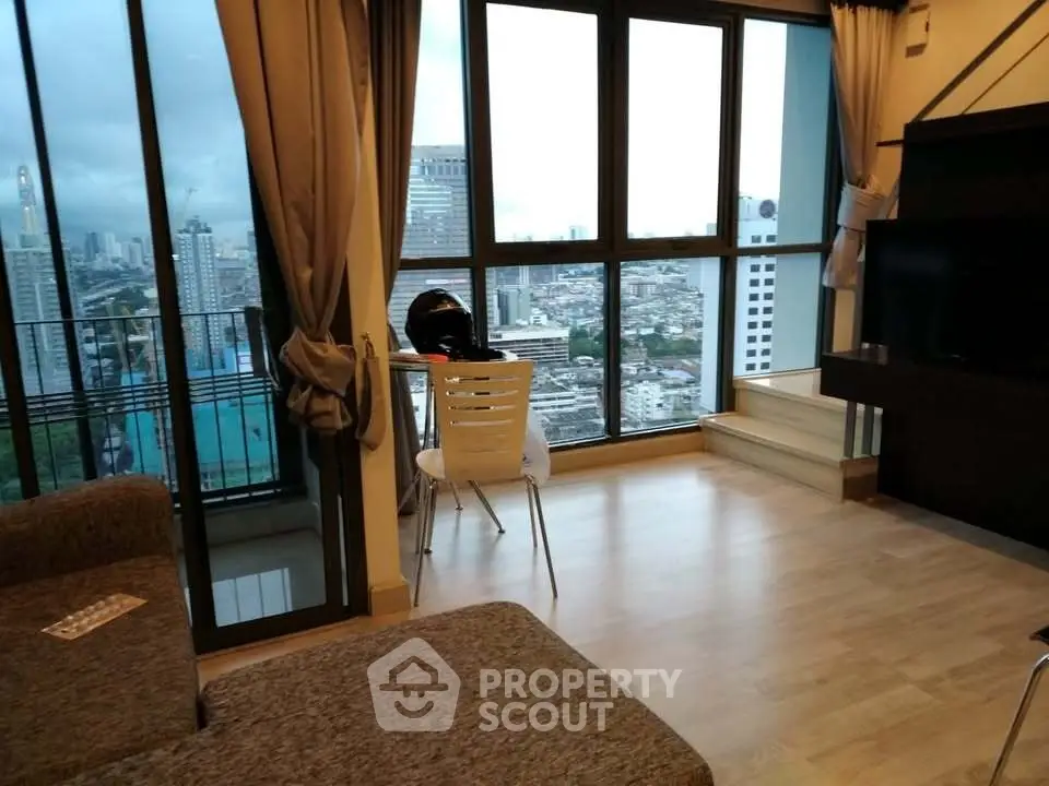 Modern living room with city view and balcony access in high-rise apartment