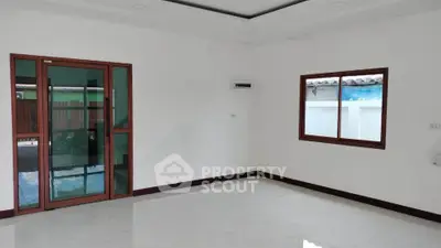 Spacious unfurnished room with large windows and sliding glass door, perfect for customization.