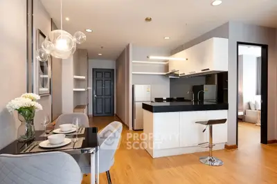 Modern open-plan kitchen and dining area with stylish decor and lighting.