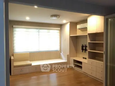 Spacious living room with built-in storage and modern lighting