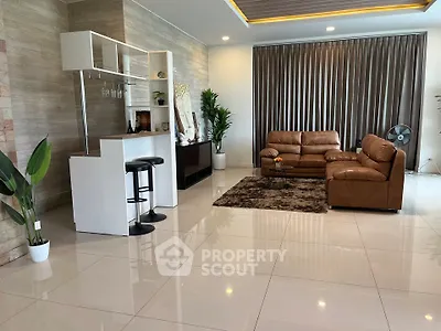 Spacious modern living room with elegant decor and leather sofas, perfect for relaxation and entertainment.