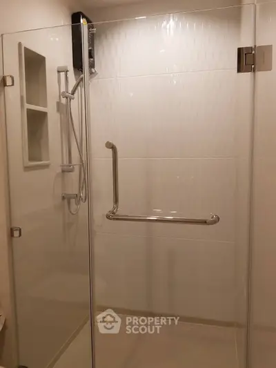 Modern bathroom with glass shower enclosure and safety grab bar