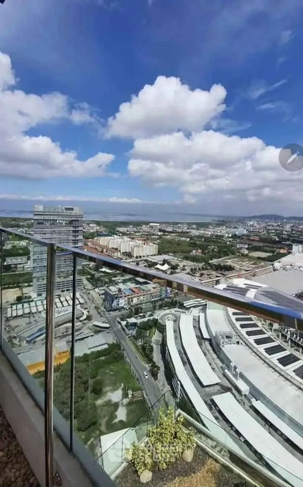 Stunning high-rise balcony view with expansive cityscape and blue sky, perfect for urban living.