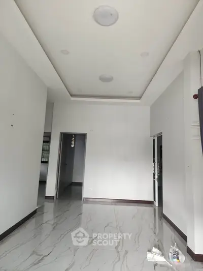 Spacious modern interior with marble flooring and recessed lighting, ideal for customization.