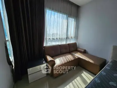 Modern living room with brown sectional sofa and large windows with sheer curtains.