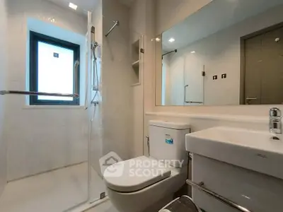 Modern bathroom with glass shower and sleek fixtures in a contemporary apartment.
