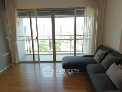Spacious living room with large windows and city view balcony