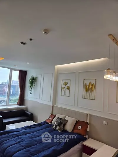Modern bedroom with stylish decor and city view, featuring elegant wall art and cozy bedding.