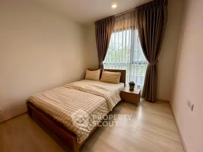 Cozy bedroom with natural light and stylish decor in modern apartment.