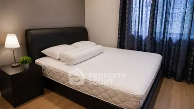 Cozy bedroom with modern decor and natural light, featuring a comfortable bed and stylish nightstand.