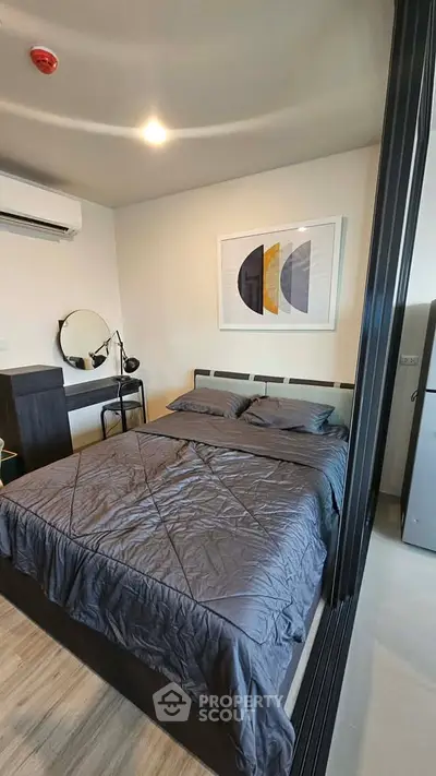 Modern bedroom with stylish decor and cozy bedding in a contemporary apartment.