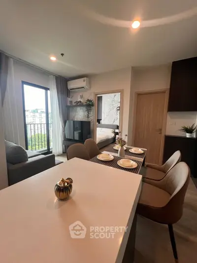 Modern open-plan living room with dining area and balcony view in stylish apartment.