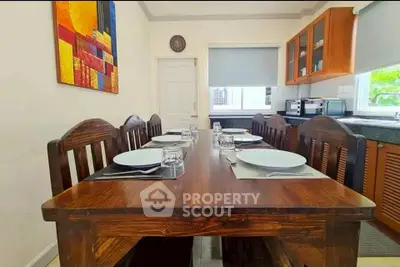 Charming dining area with wooden table and modern kitchen in cozy home.