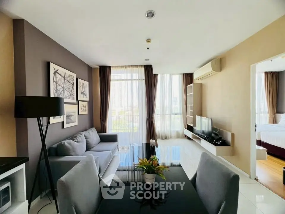 Modern living room with stylish decor and natural light in a high-rise apartment.