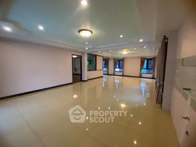 Spacious open-plan living room with elegant lighting and large windows