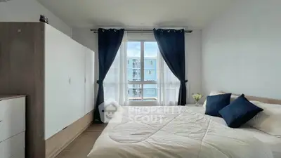 Bright and cozy bedroom with large window and modern furnishings in a stylish apartment.