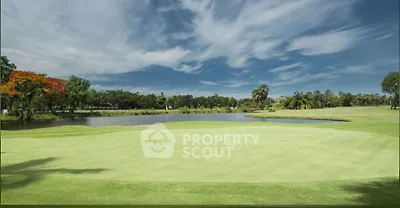 Stunning golf course view with lush greenery and serene water feature under a vibrant sky.