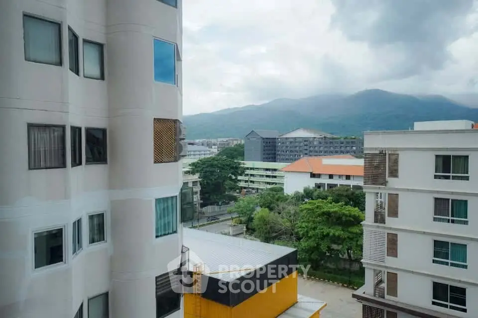Stunning urban view from high-rise apartment with mountain backdrop