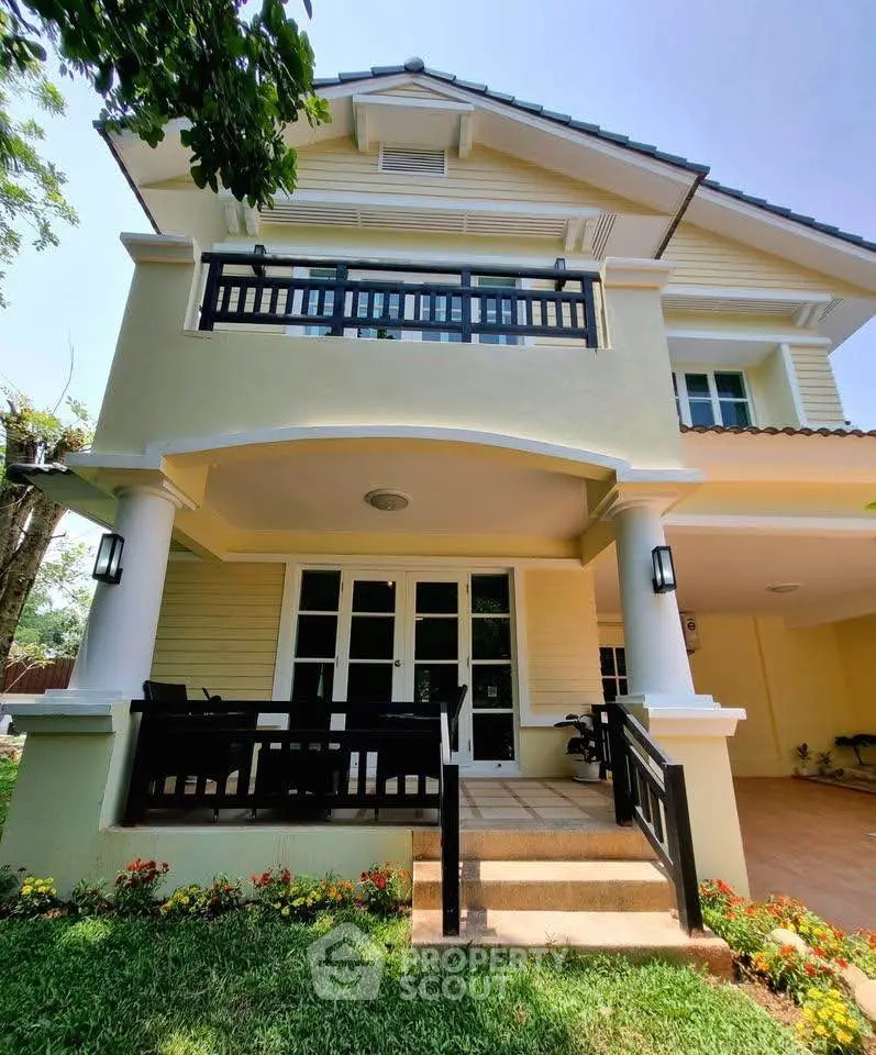 Charming two-story house with elegant balcony and lush garden, perfect for family living.