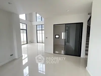 Spacious modern living room with high ceilings and large windows in a contemporary home.