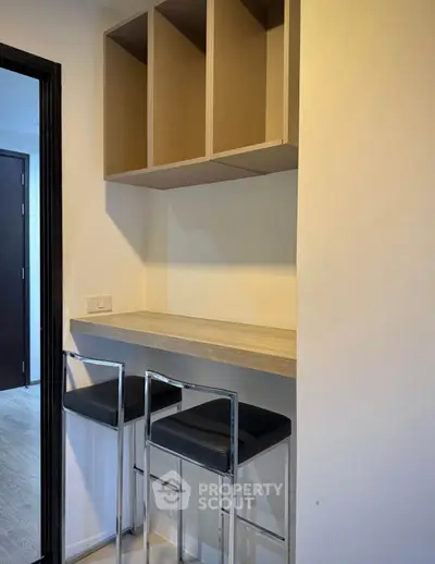 Modern minimalist breakfast bar with sleek stools and open shelving