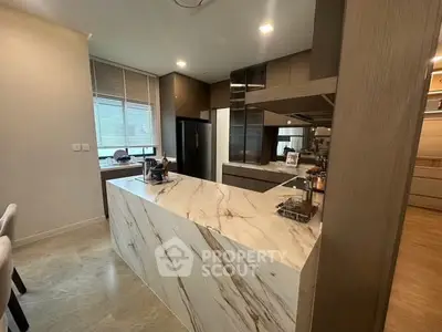 Modern kitchen with marble island and sleek cabinetry in a stylish home.