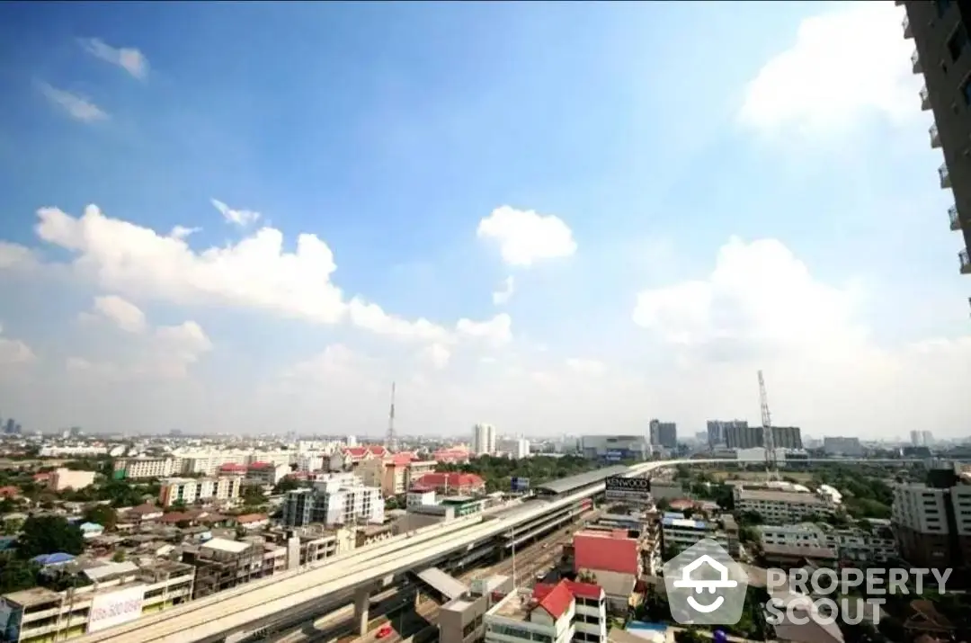 Expansive cityscape view from a high-rise balcony showcasing urban living with clear skies and a bustling metropolis, ideal for modern lifestyles.