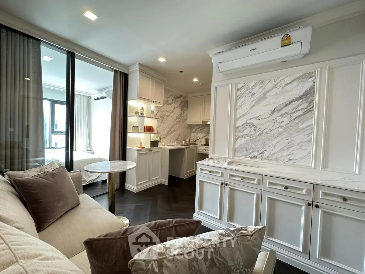 Luxurious open-layout living room with elegant marble accents and modern kitchen design.