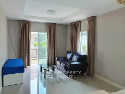 Spacious living room with modern sofa and balcony access in a bright apartment.
