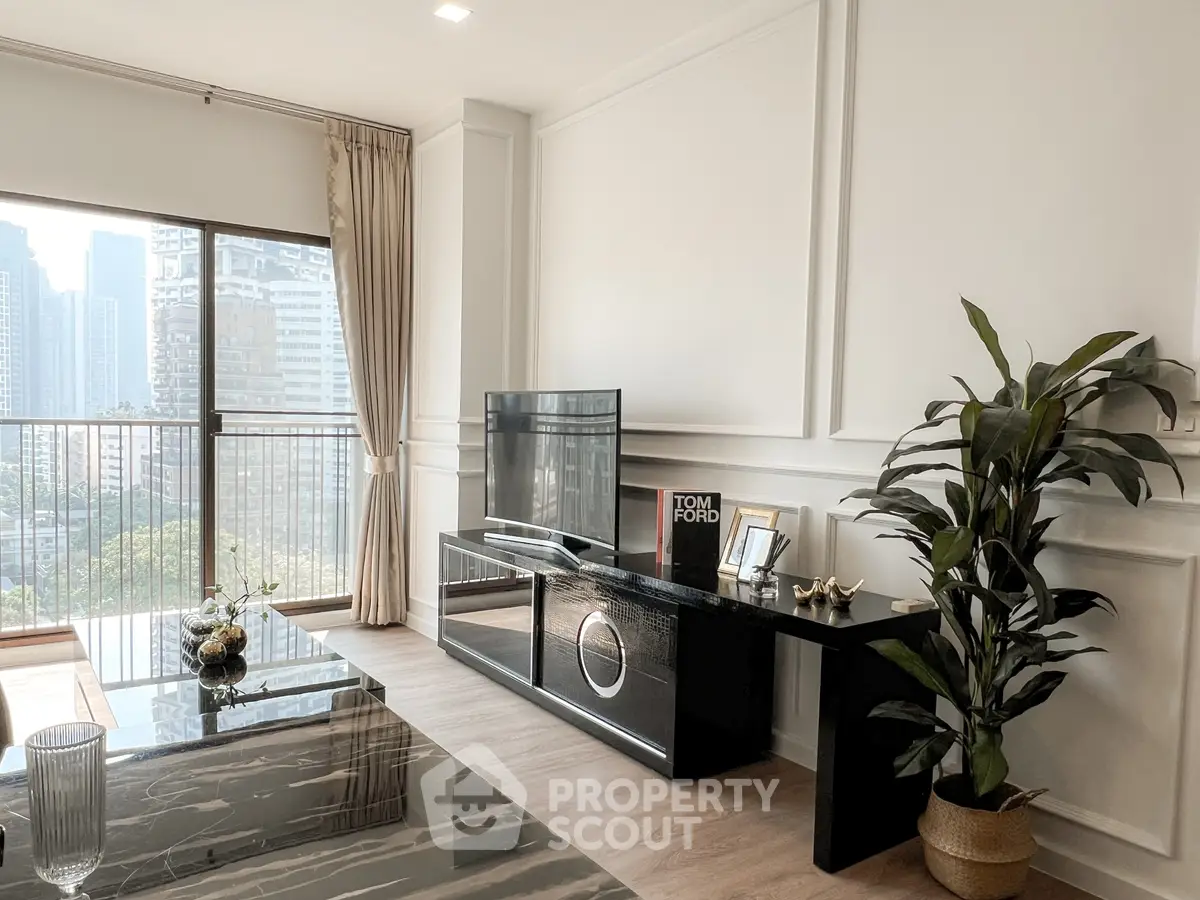 Modern living room with city view, sleek black furniture, and elegant decor.