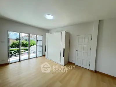 Spacious bedroom with large windows and built-in wardrobe, offering natural light and modern design.