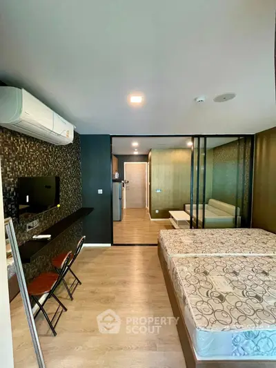 Modern studio apartment with open layout, featuring a cozy bedroom and living area with stylish decor.