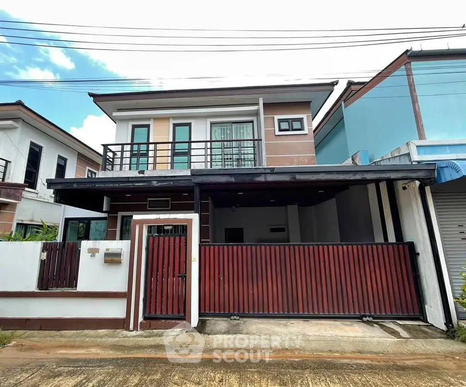 Modern two-story house with sleek design and gated entrance in a suburban neighborhood.