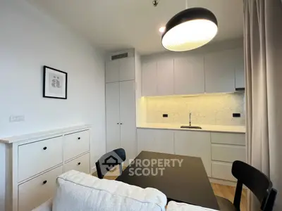 Modern kitchen with sleek cabinetry and dining area in stylish apartment
