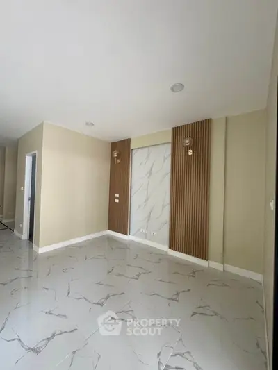 Spacious modern living room with elegant marble flooring and stylish wall accents.