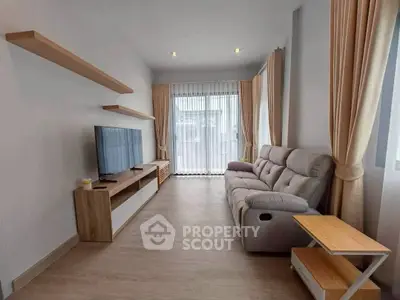 Modern living room with sleek furniture and large windows for natural light.