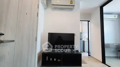 Modern living room with sleek TV setup and air conditioning in a stylish apartment.