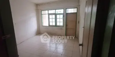 Spacious empty room with tiled floor and large window, ideal for customization.