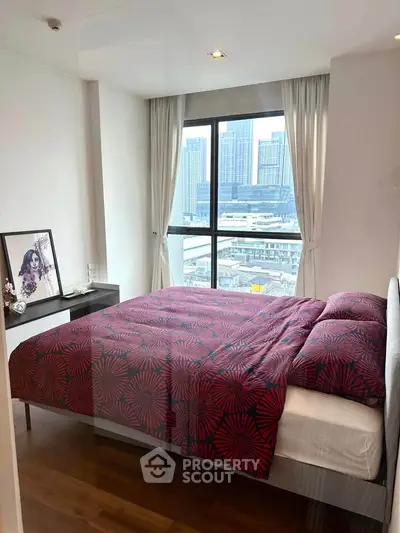 Modern bedroom with city view, stylish decor, and large window for natural light.