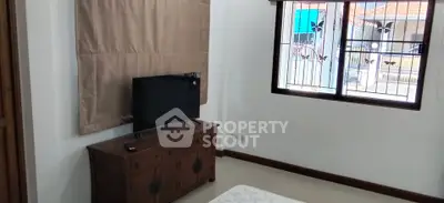 Cozy bedroom with wooden furniture and window view in a charming home