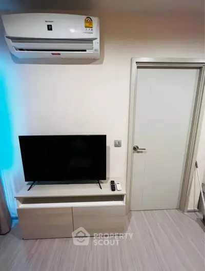 Modern living room with sleek TV stand and air conditioning unit, perfect for cozy entertainment.