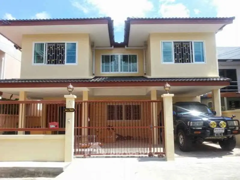 Charming two-story house with gated driveway and attached garage in a serene neighborhood.