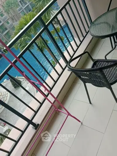 Charming balcony with pool view, perfect for relaxation and outdoor dining.